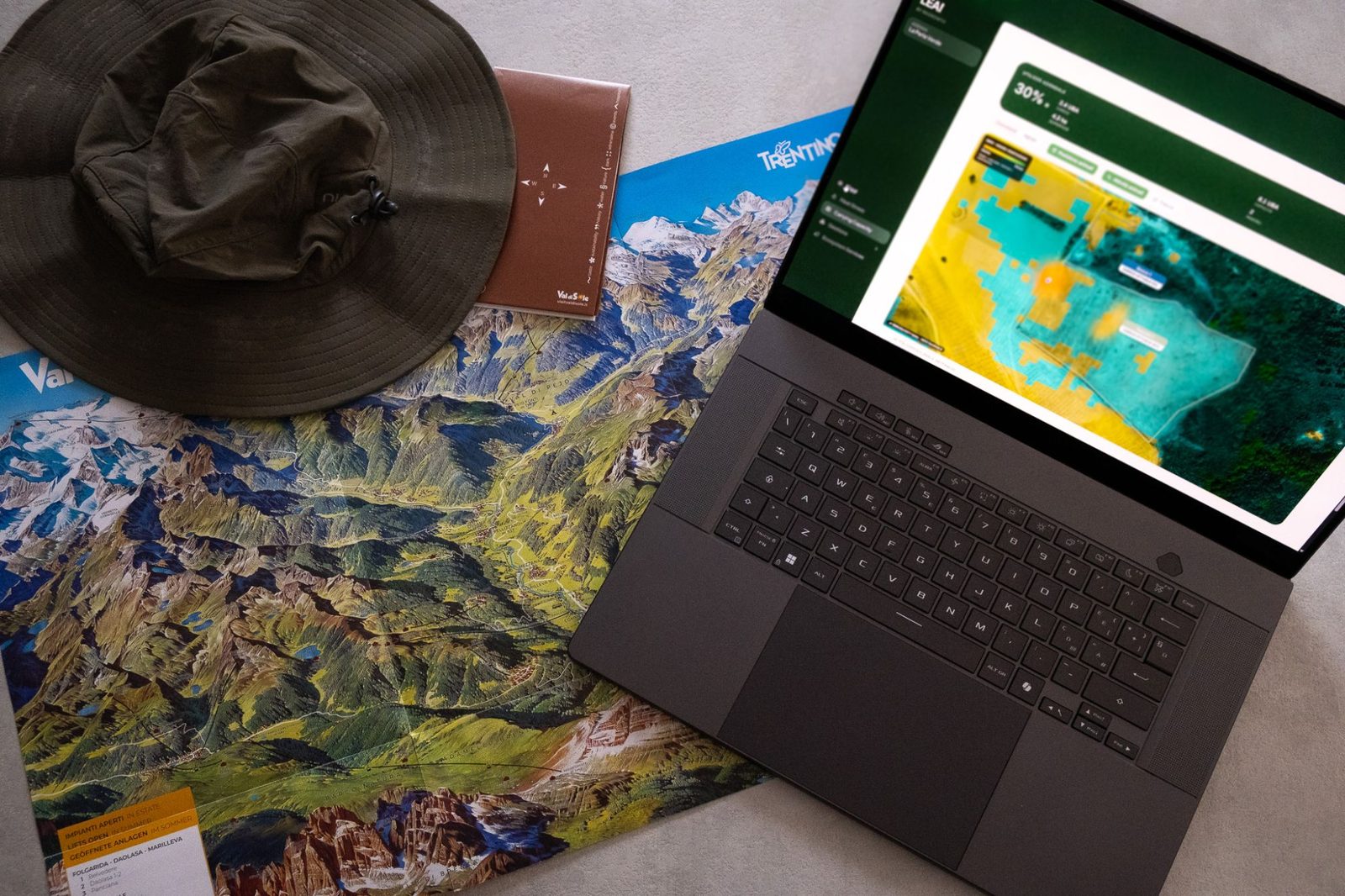 LEAF LiveTrack open on a laptop next to a map of Val di Sole